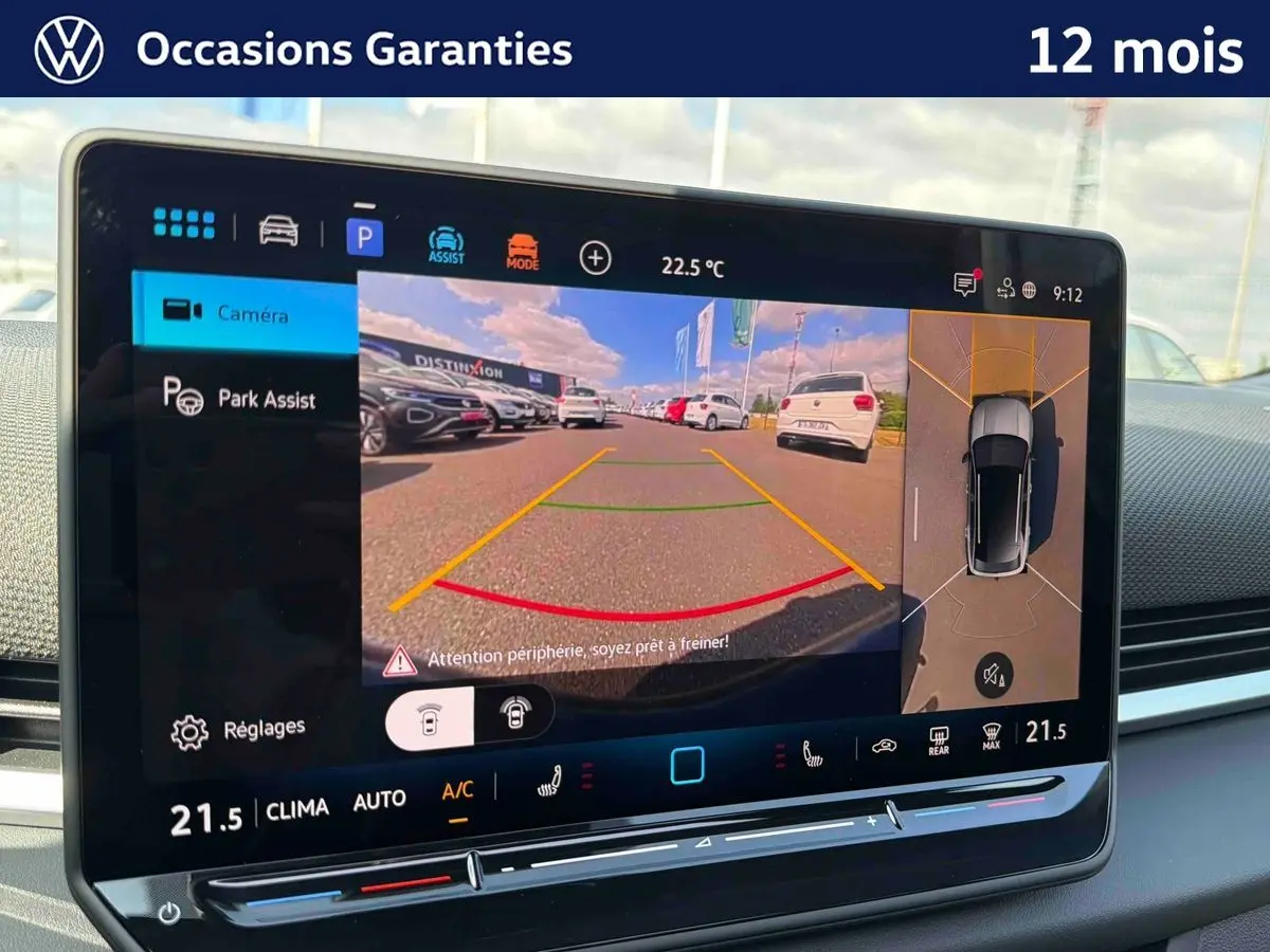 Vue intérieure de l'écran tactile du Volkswagen T-Roc noir montrant l'assistance au stationnement avec caméra et vue périmétrique 360°.