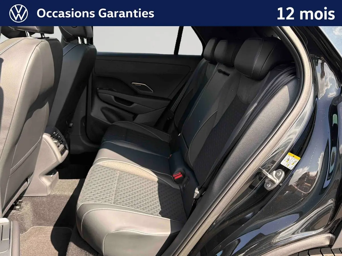 Vue intérieure côté droit des sièges arrière en cuir noir et tissu du Volkswagen T-Roc 2026 avec porte ouverte.