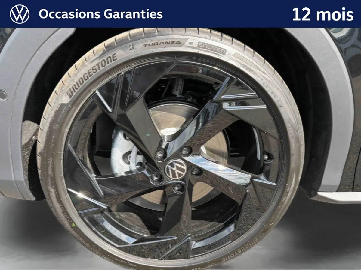 Gros plan sur la jante noire brillante 20 pouces du Volkswagen T-Roc 2026, avec pneu Bridgestone et logo VW central.