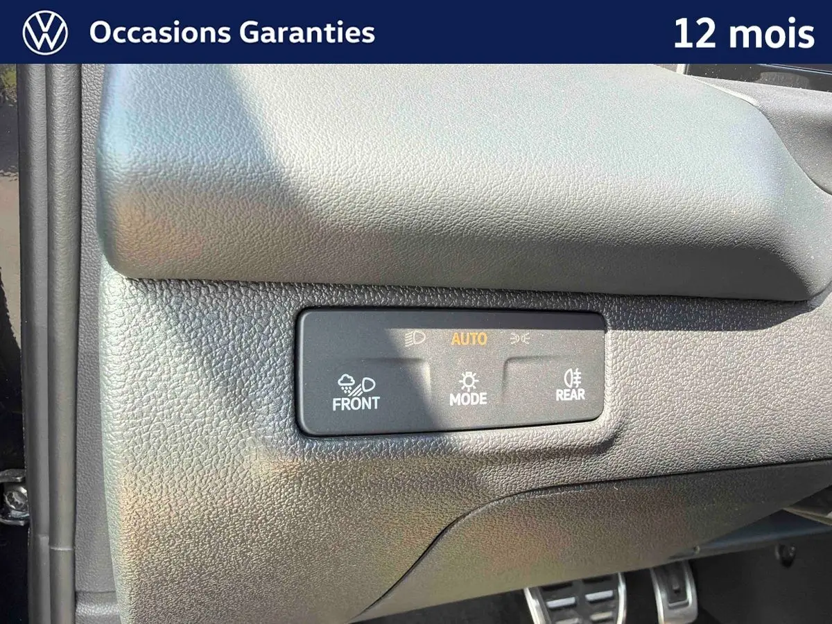 Détail du tableau de bord noir du Volkswagen T-Roc 2026 avec commandes d’éclairage automatiques.