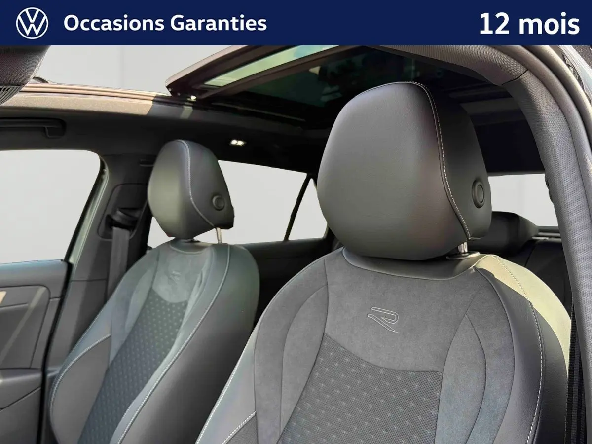 Gros plan sur les sièges avant en cuir noir avec surpiqûres blanches et toit ouvrant panoramique du Volkswagen T-Roc 2026.