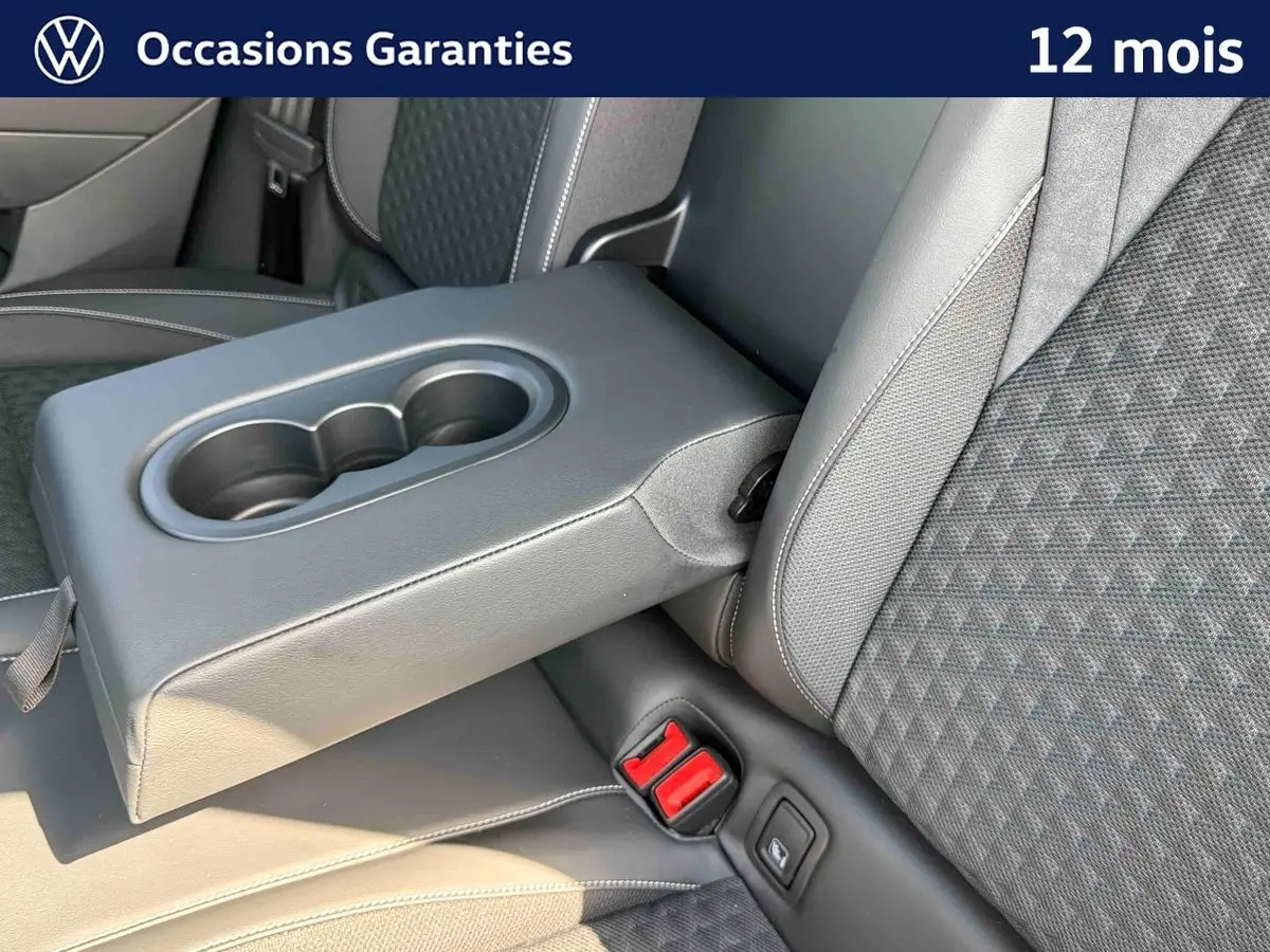 Détail de l'accoudoir central arrière avec porte-gobelets et sellerie tissu gris du Volkswagen T-Roc noir.