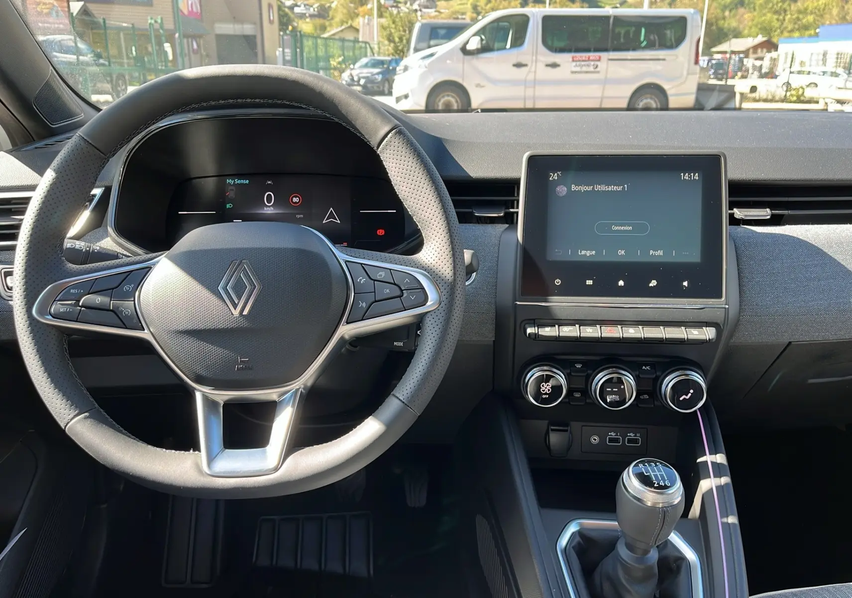 Intérieur de la Renault Clio V Facelift TCe 90 Techno 2025, volant multifonction et écran tactile au centre, boîte manuelle visible.