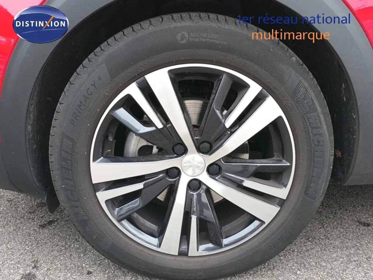 Gros plan sur la jante bi-ton en alliage du côté arrière droit d'un Peugeot 3008 rouge foncé métal.