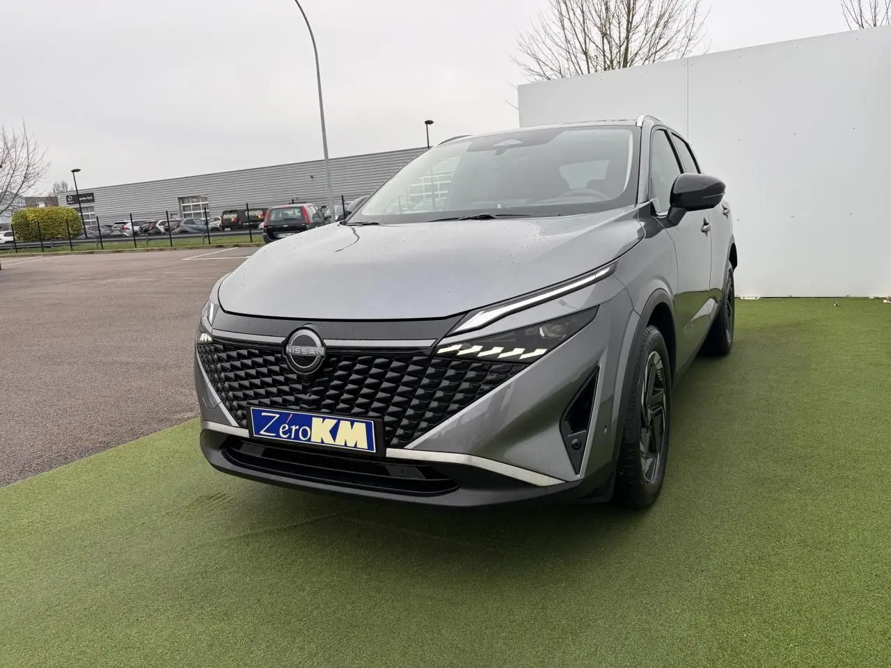 Nissan Qashqai III 1.5 Hybrid E-Power gris foncé, vue 3/4 avant avec calandre noire et phares LED distinctifs.