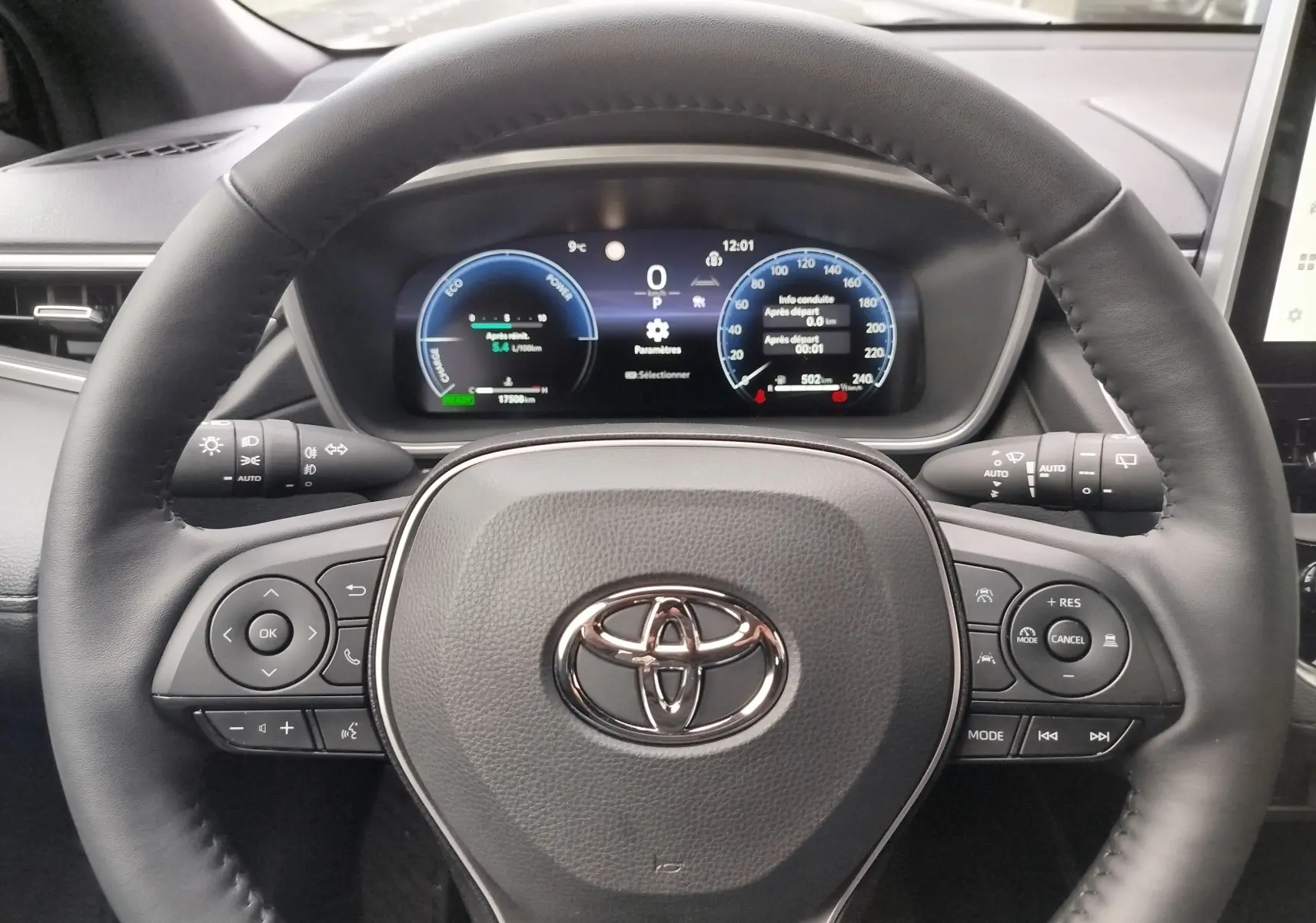 Vue rapprochée du volant noir et du tableau de bord numérique de la Toyota Corolla Cross 2025 hybride essence.