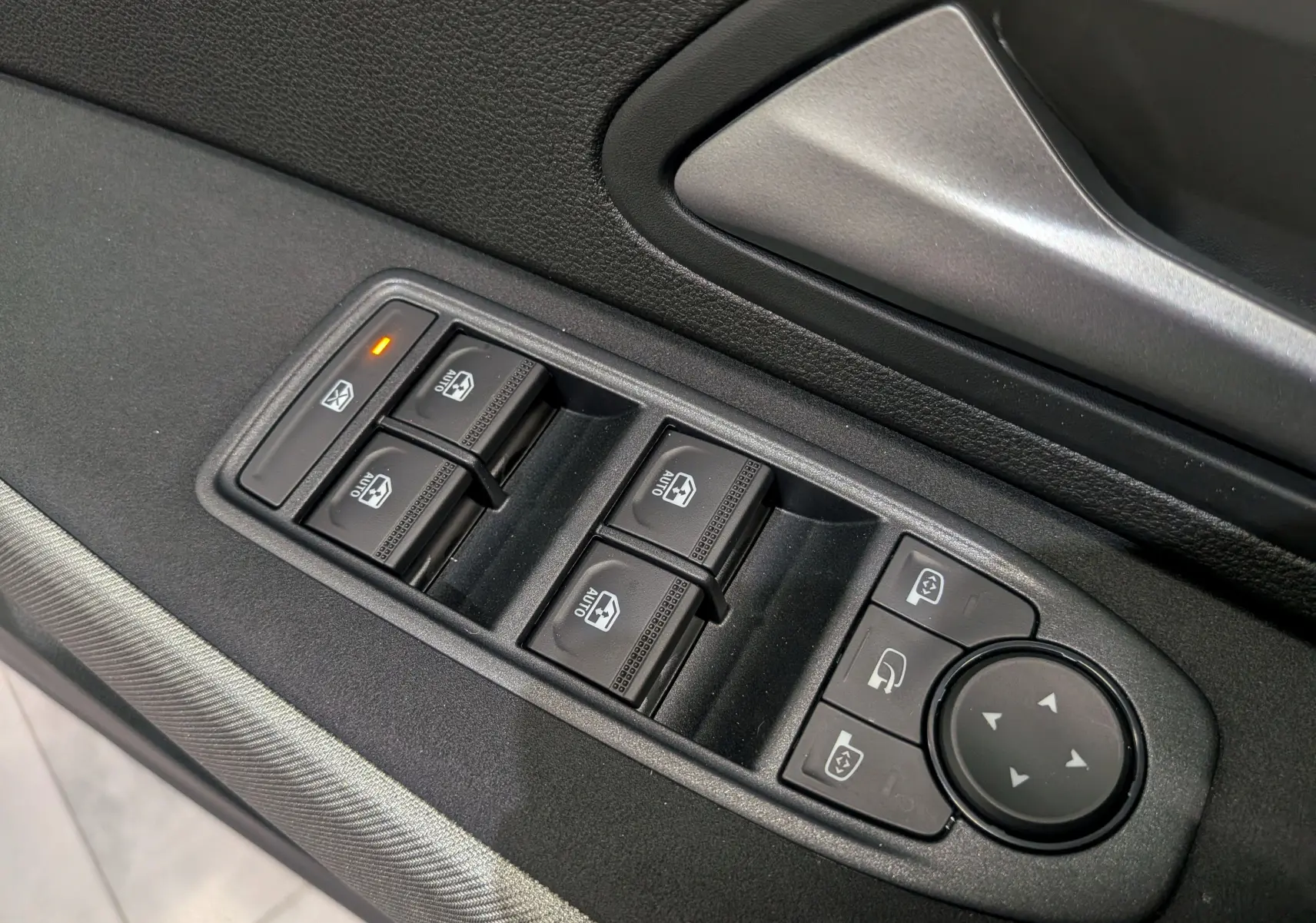 Gros plan sur les commandes de lève-vitres et réglages des rétroviseurs côté conducteur du Dacia Bigster 2026.