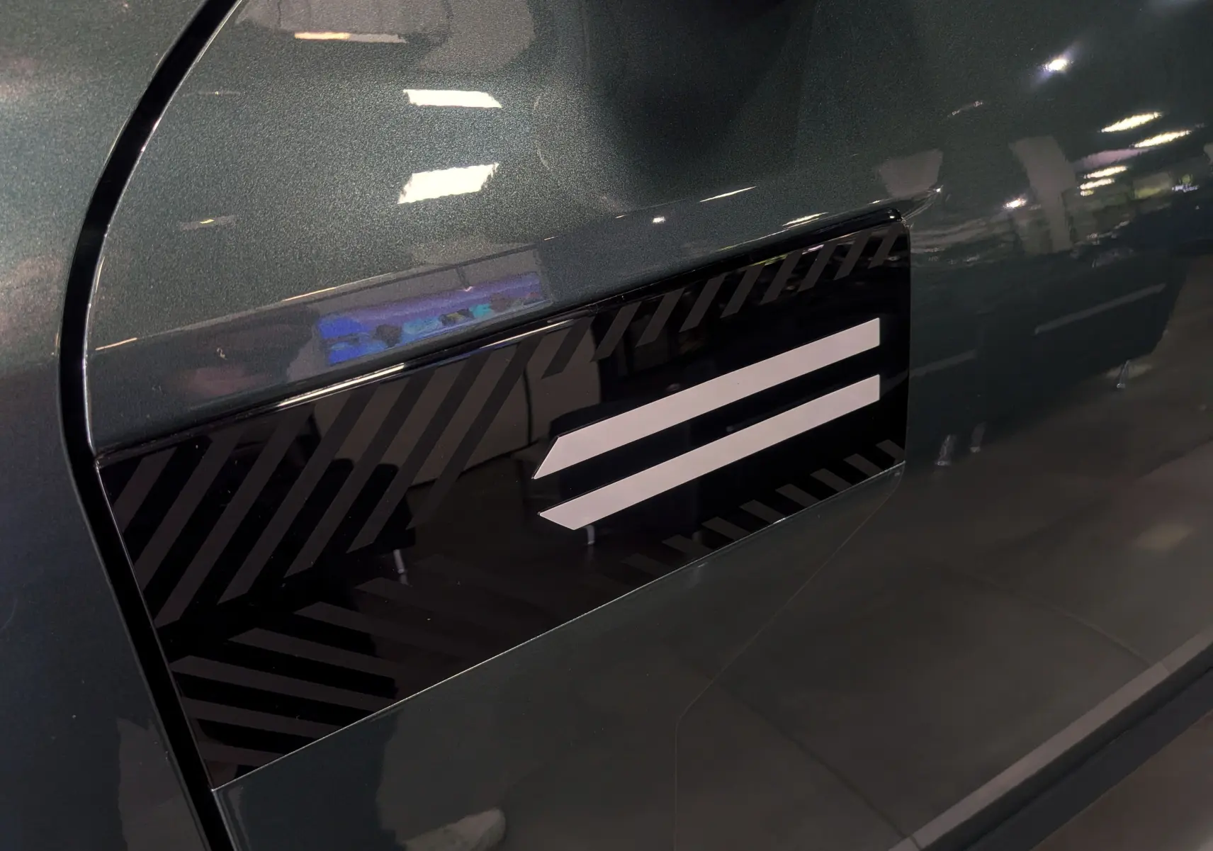 Détail du côté gauche vert cèdre du Dacia Bigster 2026 avec insert décoratif noir et blanc en motif rayé.