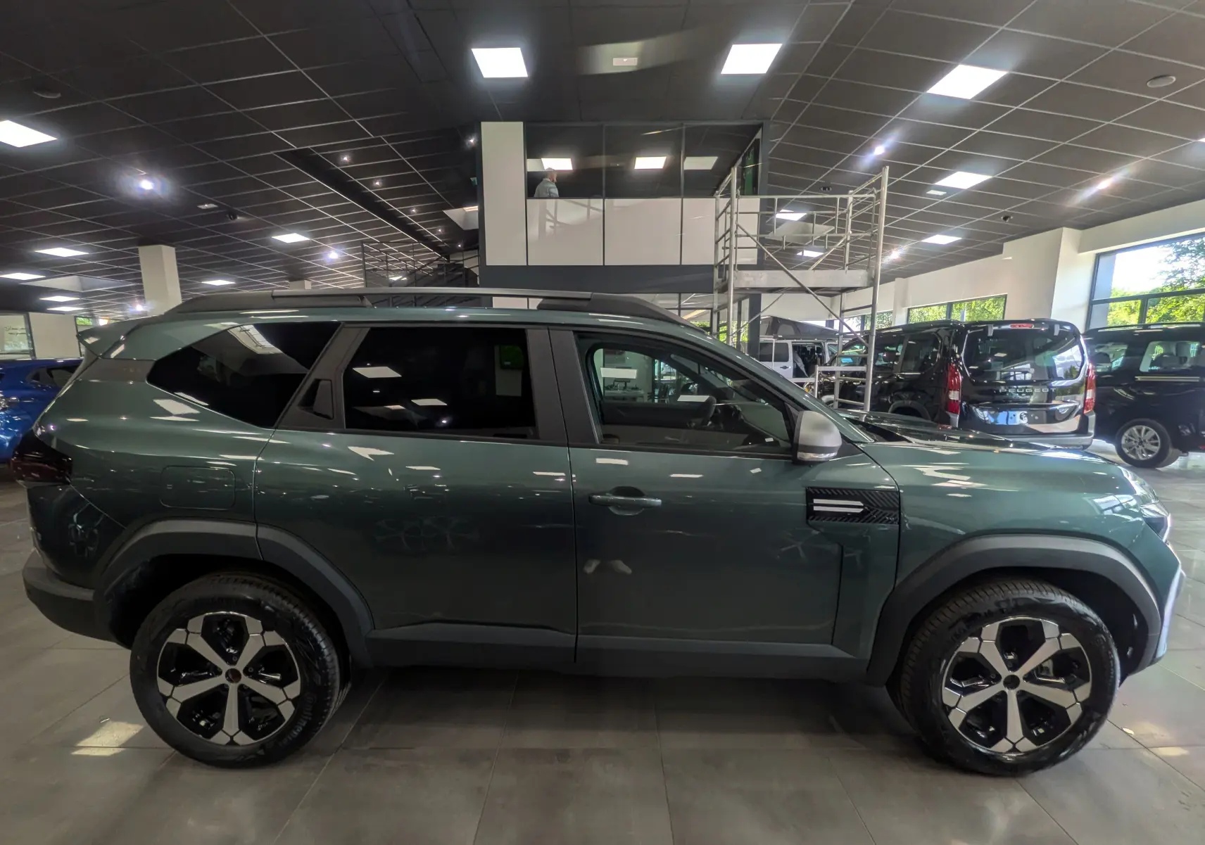 Profil droit du SUV Dacia Bigster vert cèdre 2026 en version Mild Hybrid 140 CH Journey, roues bi-ton et détails noirs.