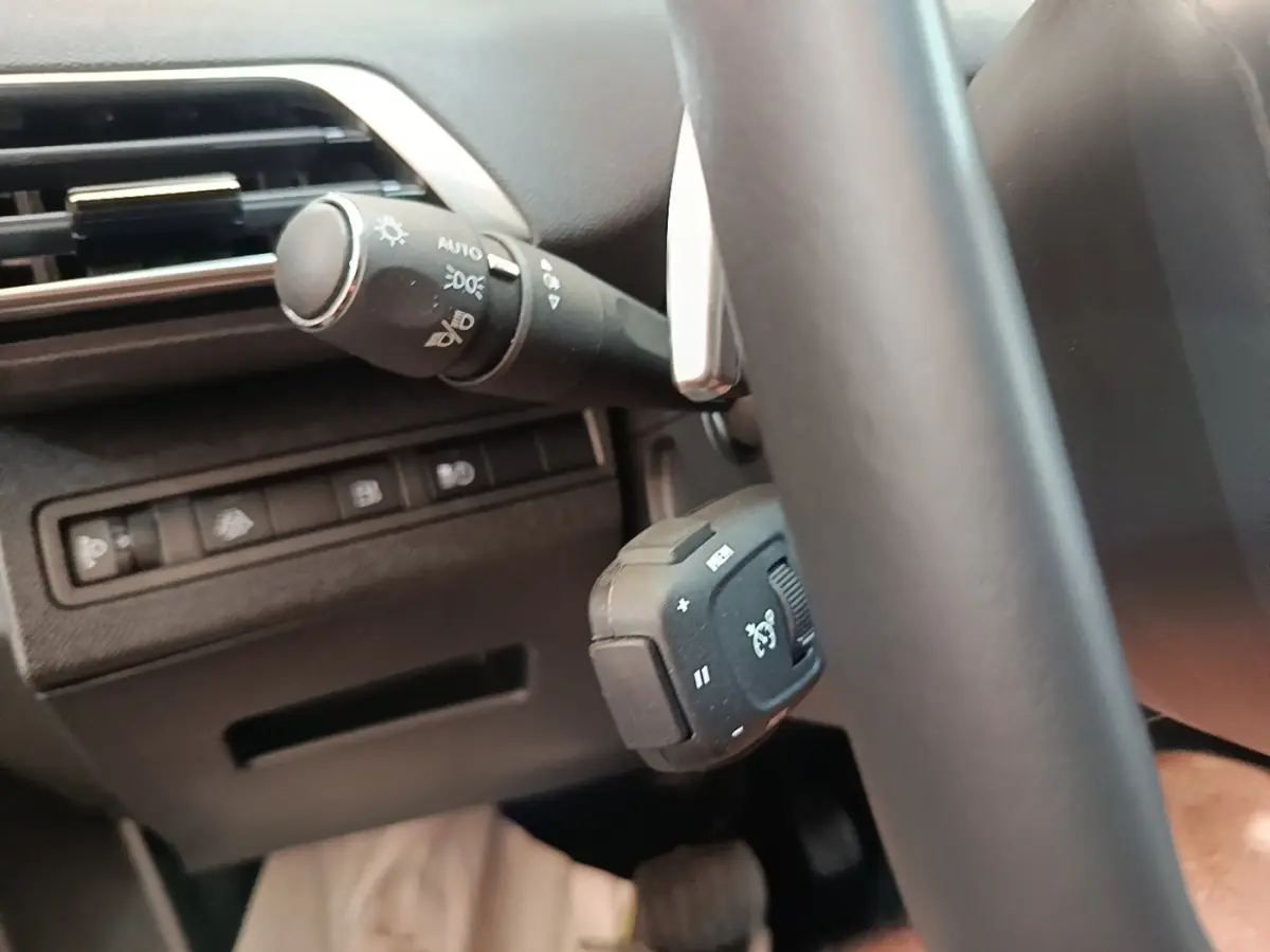 Détail du volant cuir et commandes au volant du Peugeot 3008 hybride rechargeable bleu, vue côté gauche intérieure.
