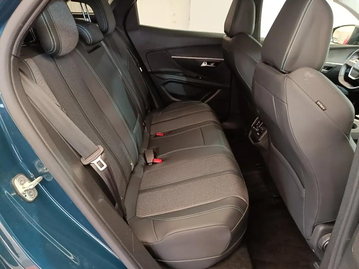 Vue intérieure côté gauche sur la banquette arrière en cuir et tissu du Peugeot 3008 bleu hybride rechargeable 2023.