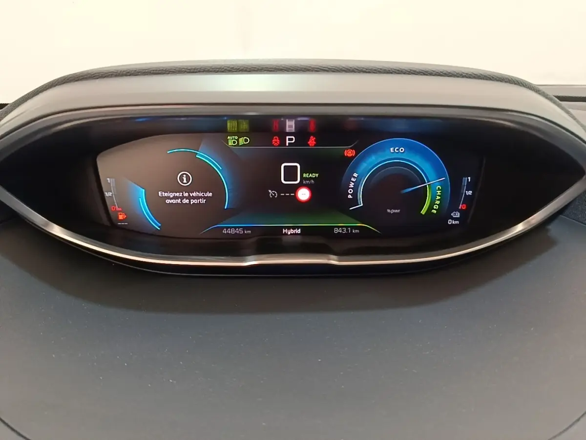 Vue rapprochée du tableau de bord numérique du Peugeot 3008 hybride rechargeable 2023, affichage couleur et indicateurs LED.