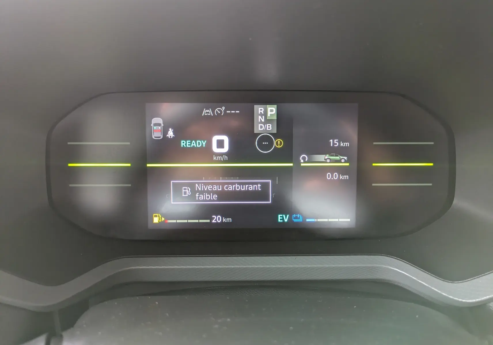 Tableau de bord numérique du Dacia Duster Hybrid 155 Extreme affichant un message de niveau carburant faible.