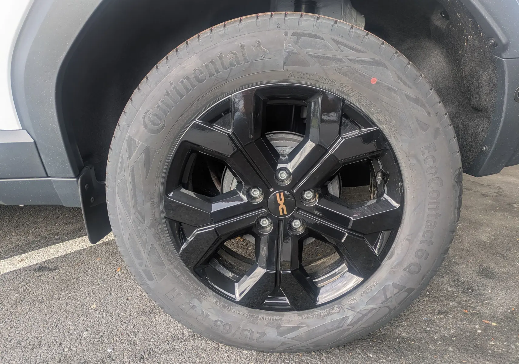 Gros plan sur la jante noire en alliage 17'' TERGAN du Dacia Duster Hybrid 155 Extreme blanc glacier, côté gauche.