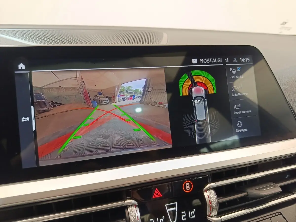Écran tactile central de BMW Série 3 320e hybride montrant la caméra de recul et l'assistance au stationnement.