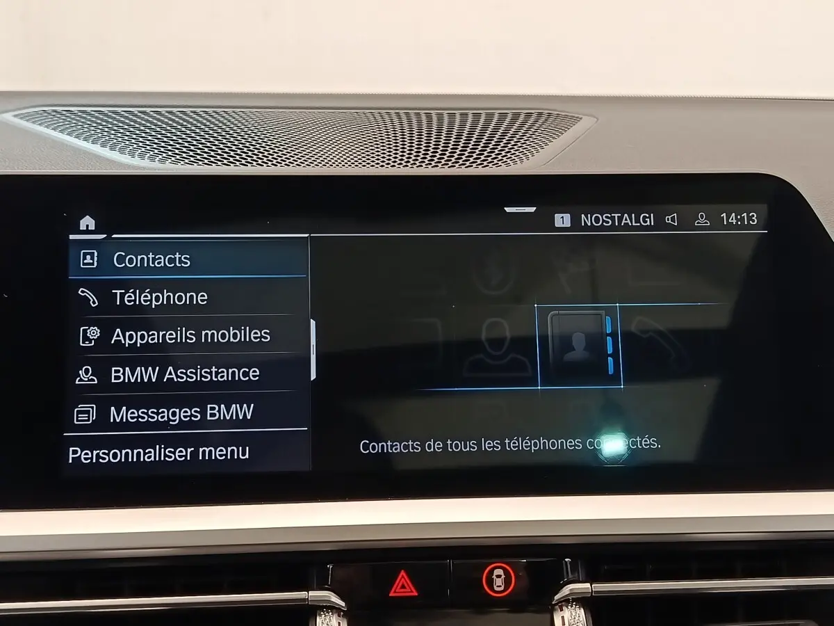 Écran tactile central de la BMW Série 3 320e gris foncé affichant le menu contacts en intérieur.