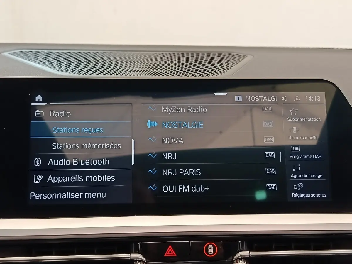 Écran tactile central affichant les stations radio DAB dans l’habitacle d’une BMW Série 3 320e gris foncé.