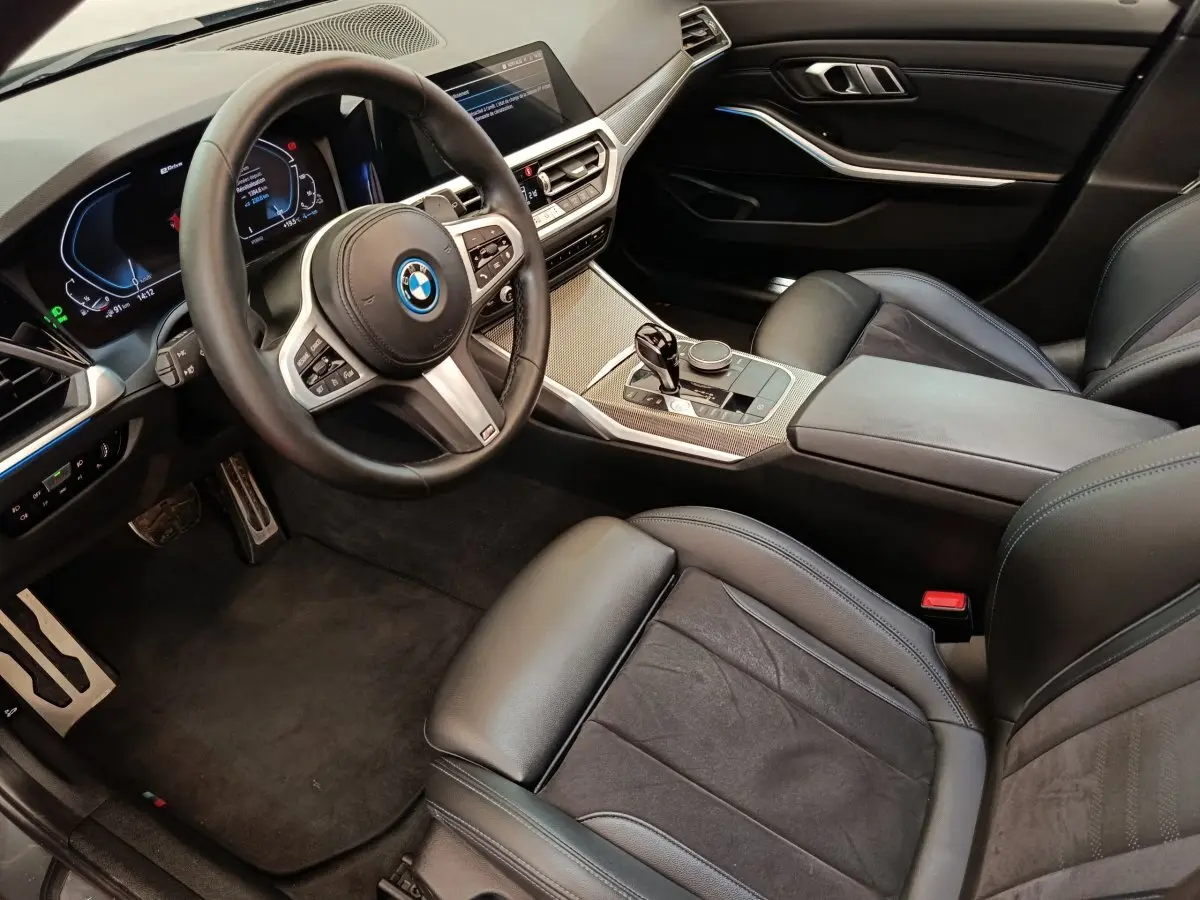 Vue intérieure côté conducteur de la BMW Série 3 320e M Sport 2022 avec tableau de bord digital et sellerie cuir noire.