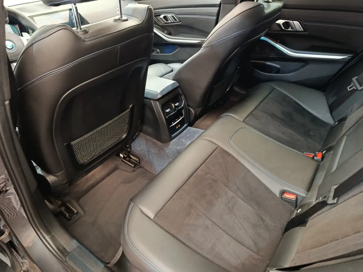 Vue intérieure arrière côté droit de la BMW Série 3 320e M Sport 2022 avec sièges cuir noir et console centrale.