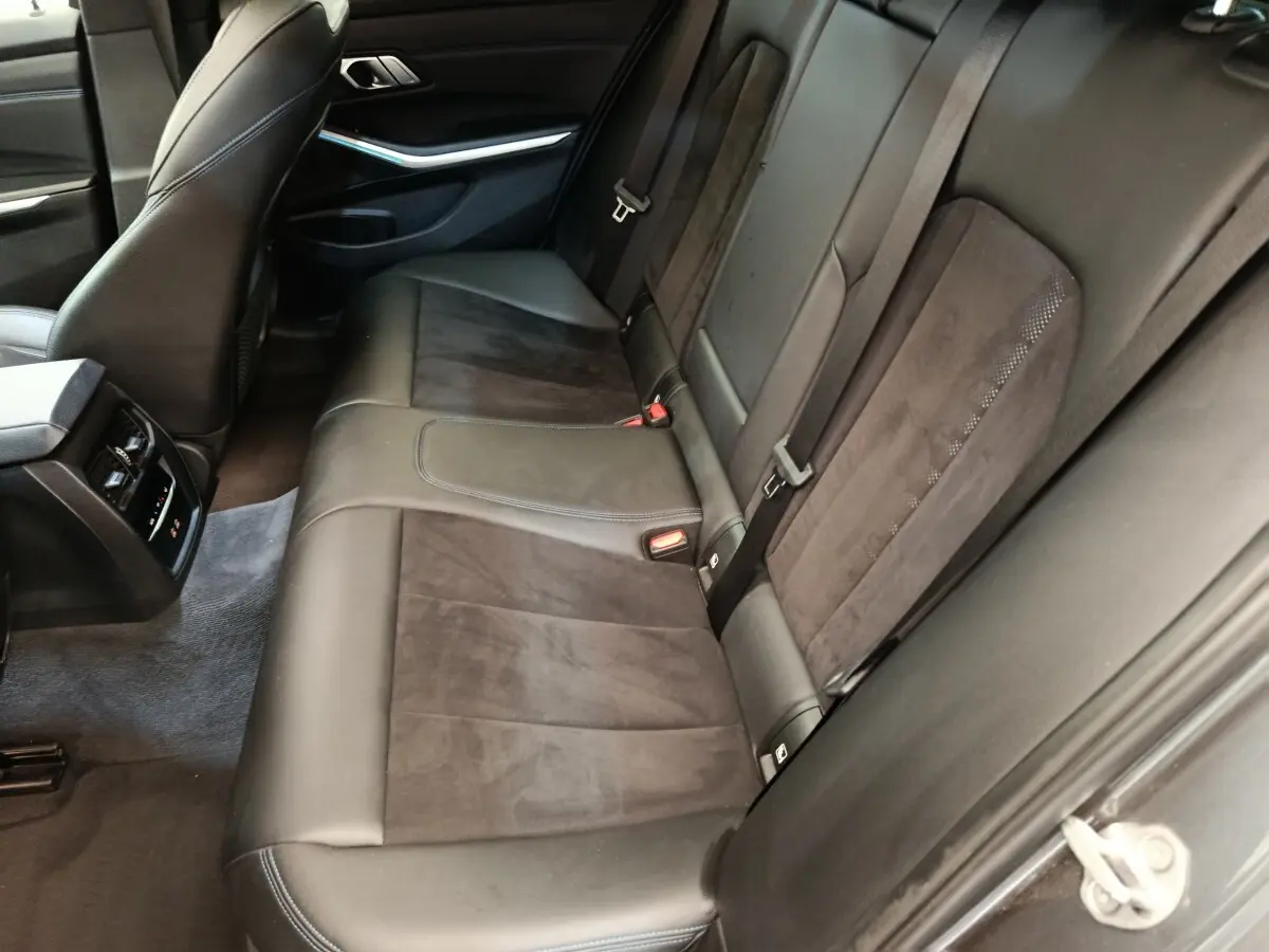 Vue côté droit de la banquette arrière en cuir noir et alcantara d’une BMW Série 3 320e M Sport 2022.