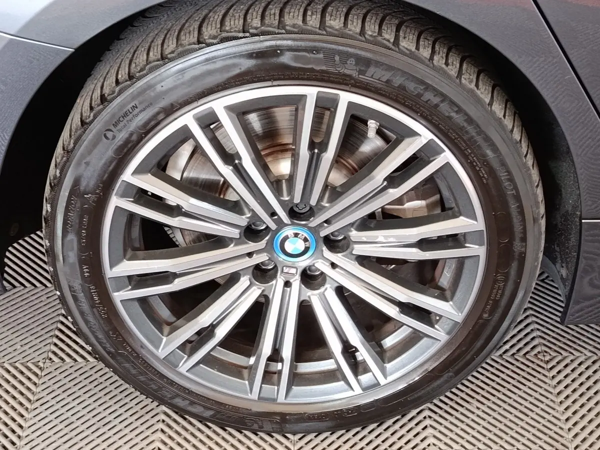 Gros plan sur la roue avant droite d'une BMW Série 3 320e M Sport gris foncé avec jante alliage multi-branches.