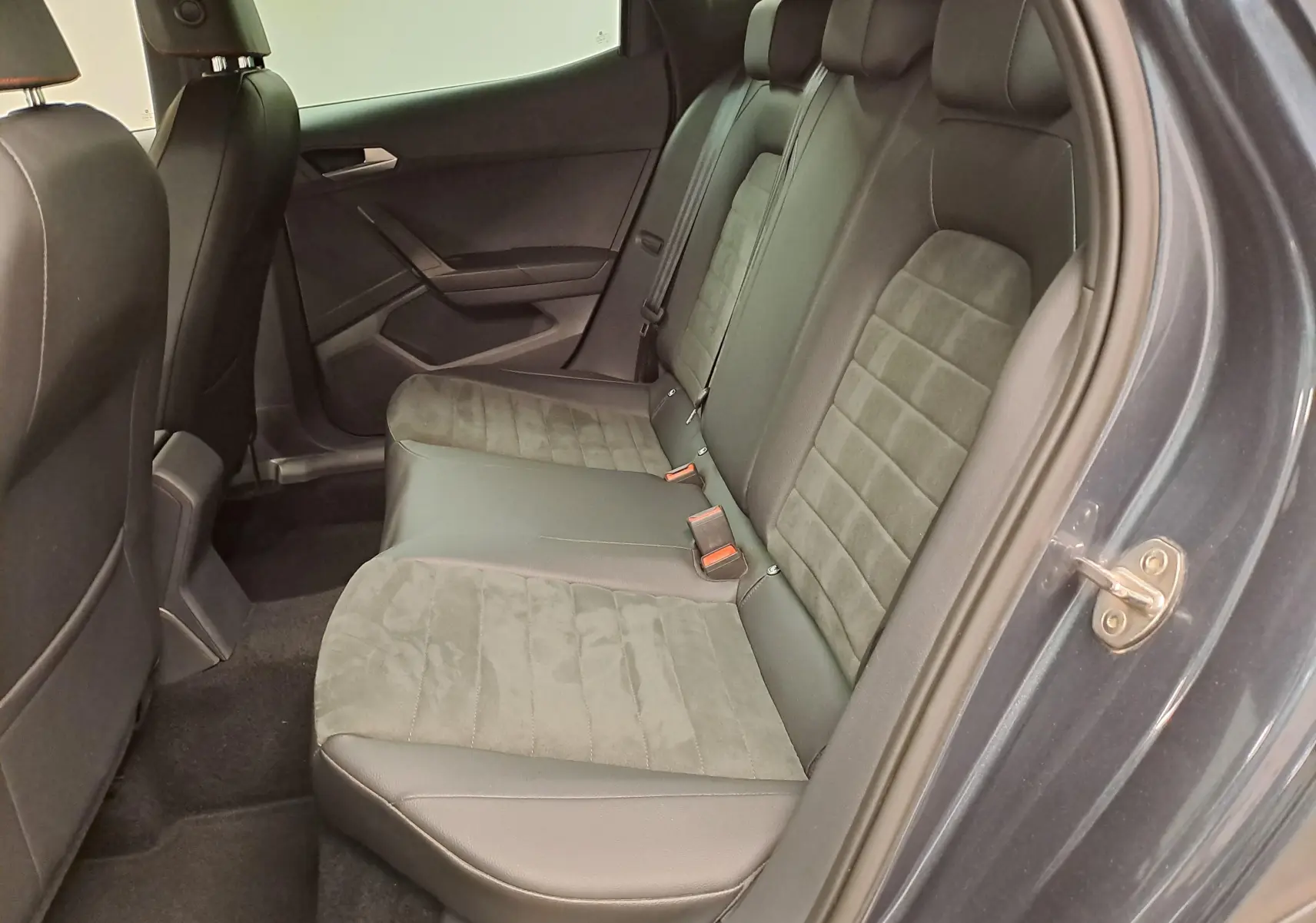 Vue intérieure côté droit des sièges arrière en tissu et cuir gris du SEAT Arona 2024 avec porte ouverte.