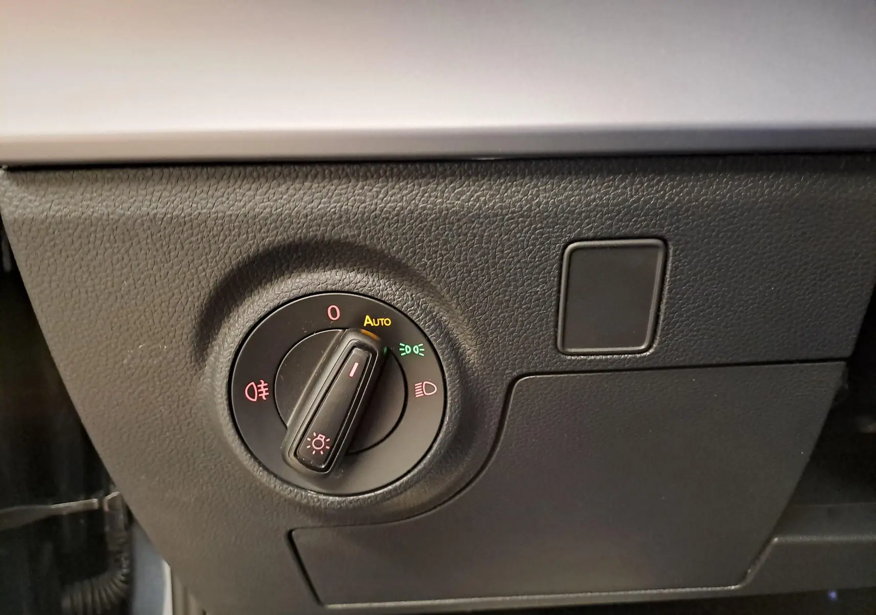 Gros plan sur le bouton de commande des phares du SEAT Arona 2024, avec réglage sur mode automatique.