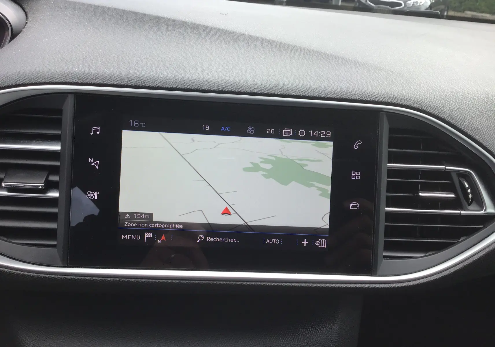 Vue rapprochée de l'écran tactile central du tableau de bord de la Peugeot 308 gris Artense, affichant la navigation GPS.