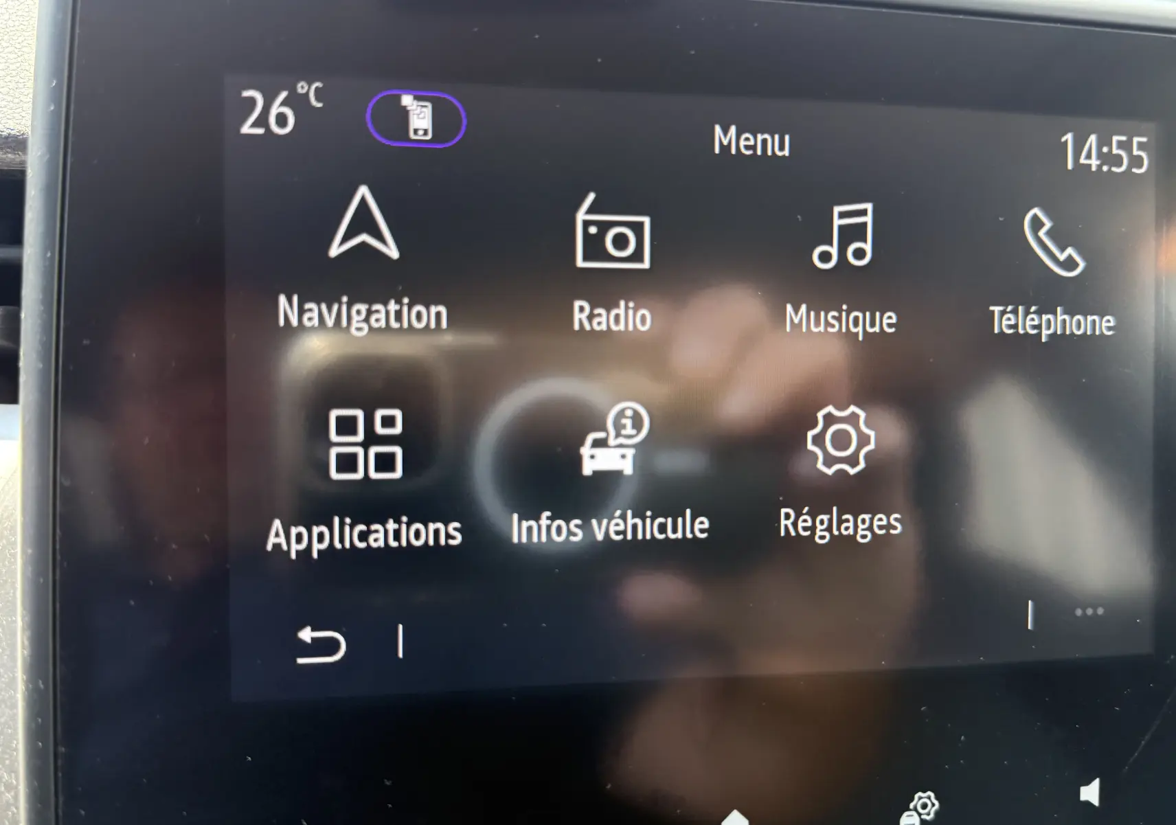 Écran tactile central de la Renault Clio V gris, affichant le menu principal avec navigation, radio et réglages.