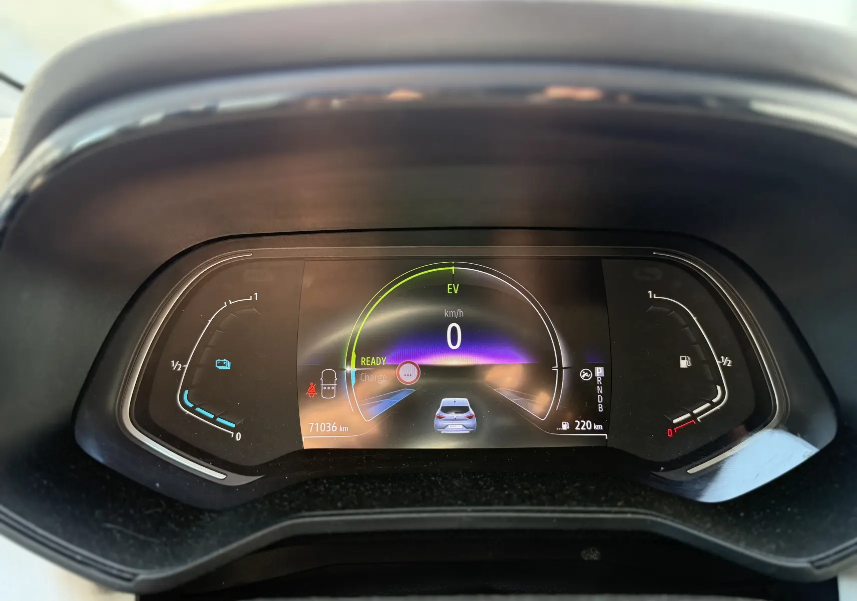 Tableau de bord numérique de la Renault Clio V hybride gris, affichant 0 km/h et 71 036 km au compteur.