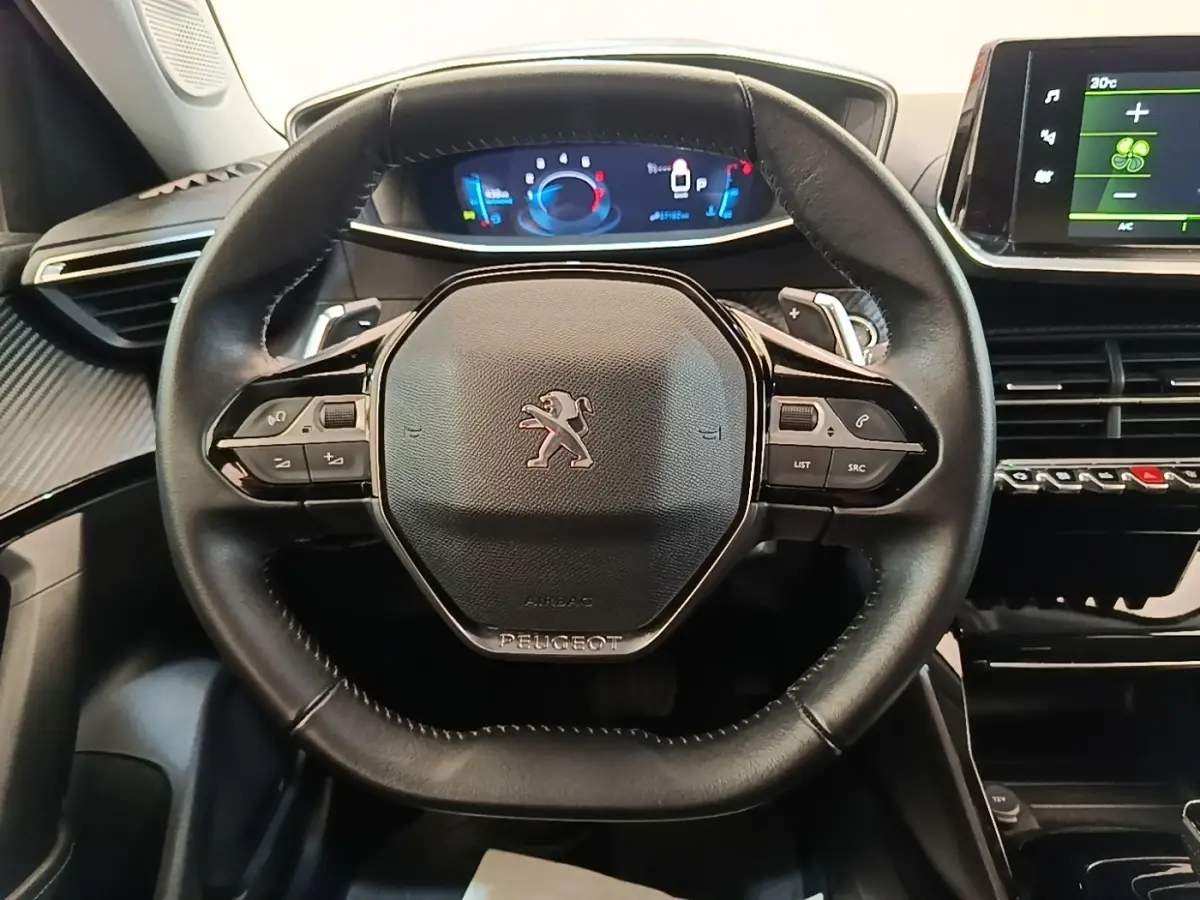 Volant cuir noir Peugeot 2008 2022 avec tableau de bord numérique et écran tactile central visible de face.
