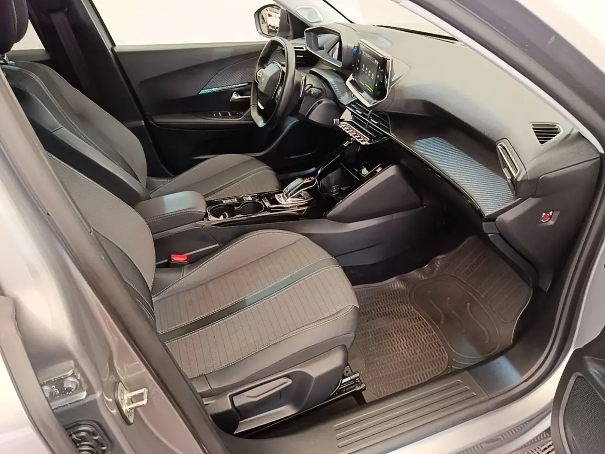 Intérieur avant droit de la Peugeot 2008 gris clair 2022, avec tableau de bord moderne et écran tactile central.