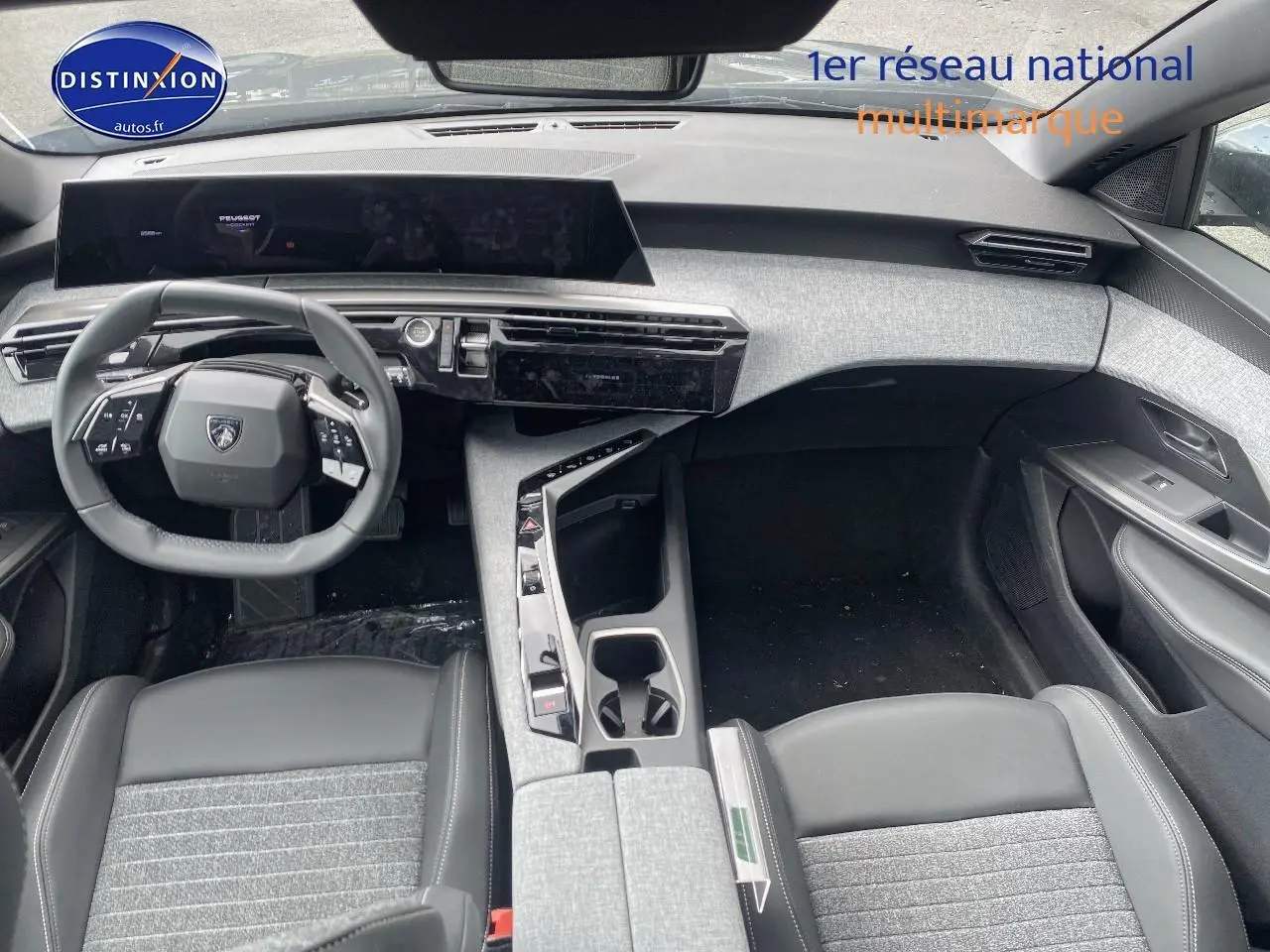 Vue intérieure avant du Peugeot 5008 Hybrid 145 allure e-dcs6 2025, tableau de bord et volant cuir noir avec inserts gris.
