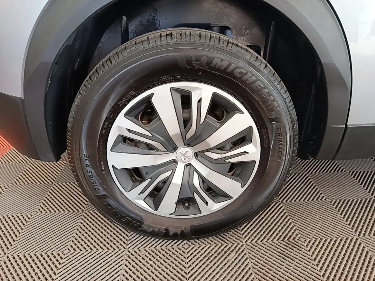 Gros plan sur la roue avant droite gris clair du Peugeot E-2008 électrique avec jante alliage et pneu Michelin.