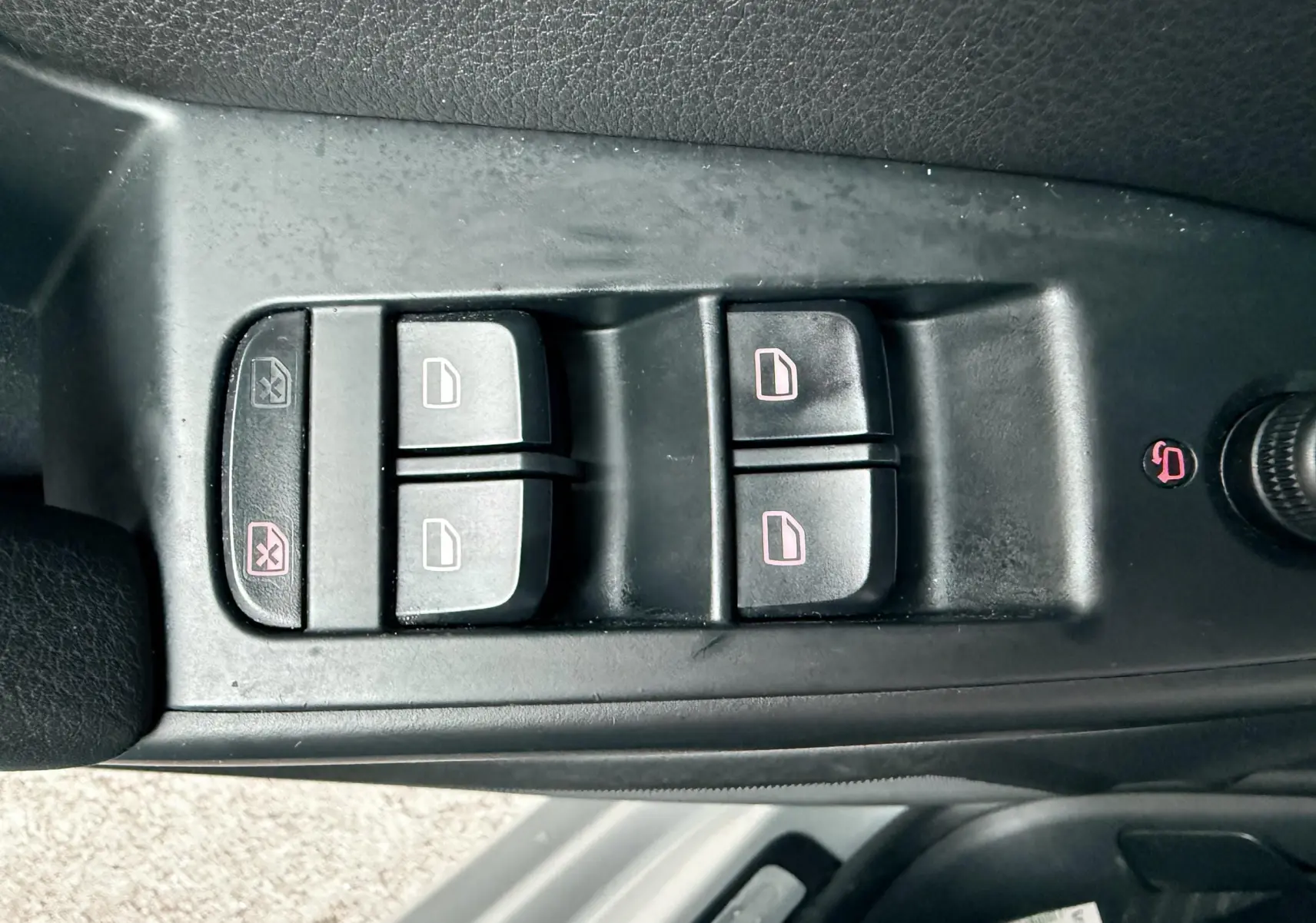 Panneau de commandes des vitres électriques et verrouillage sur la porte côté conducteur d'une Audi A5 gris 2011.