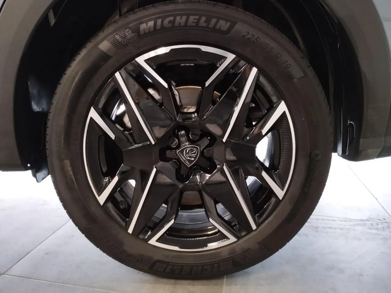 Gros plan sur la jante alliage 19'' diamantée noire et argentée du Peugeot 5008 Bleu Ingaro, pneu Michelin visible.