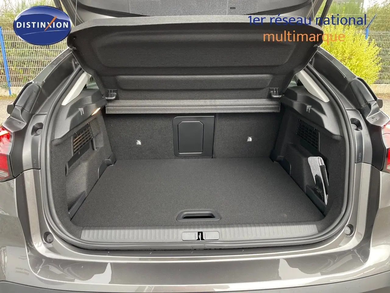 Coffre ouvert en vue arrière d'une Citroën C4 2024 gris platinium métal, montrant un espace de chargement propre et spacieux.