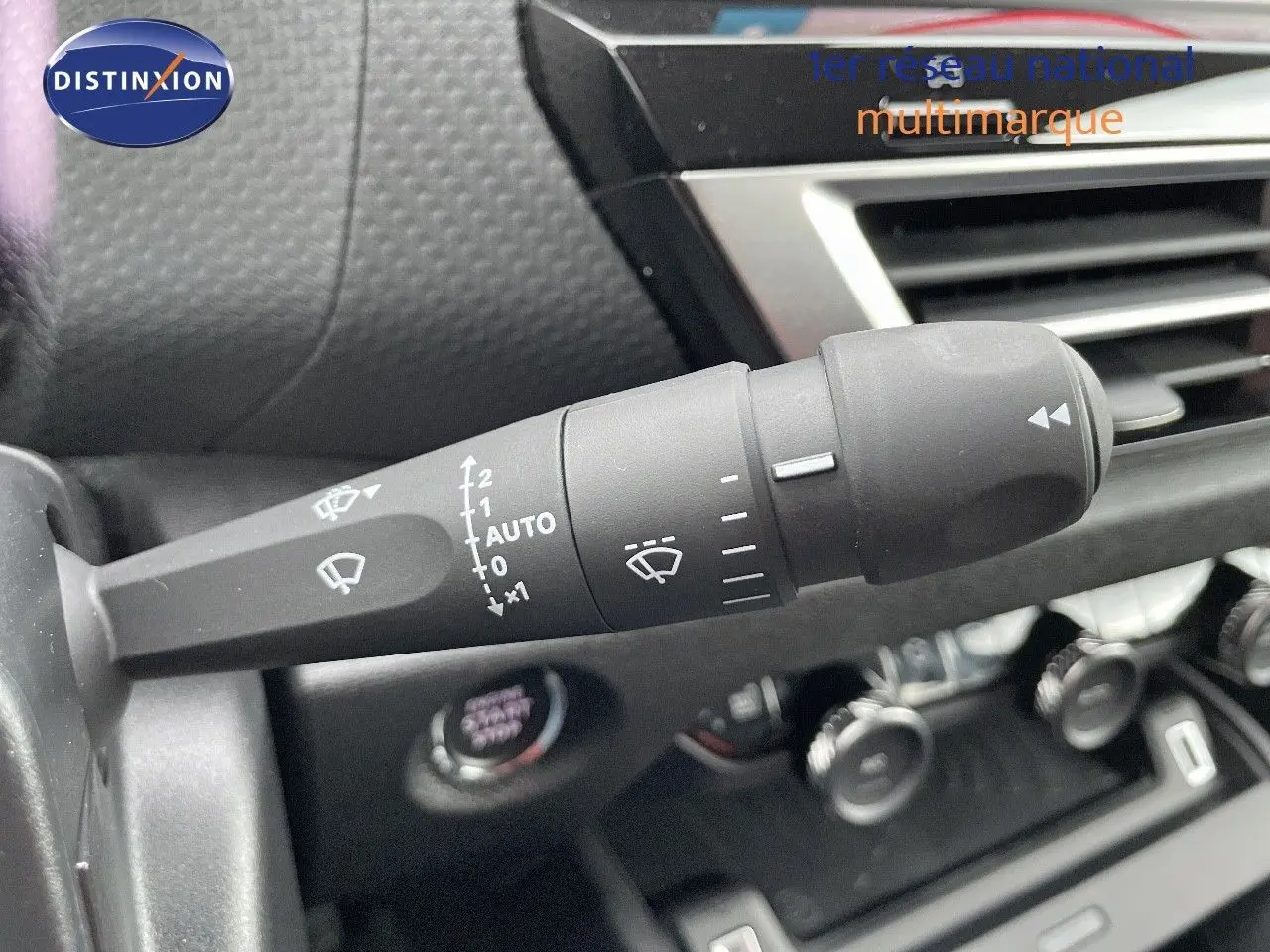 Gros plan sur la commande d'essuie-glace à gauche du volant dans l'habitacle d'une Citroën C4 gris platinium 2024.