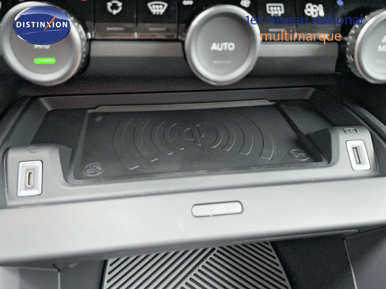 Gros plan sur la console centrale de la Citroën C4 2024, mettant en valeur le chargeur sans fil et les ports USB.