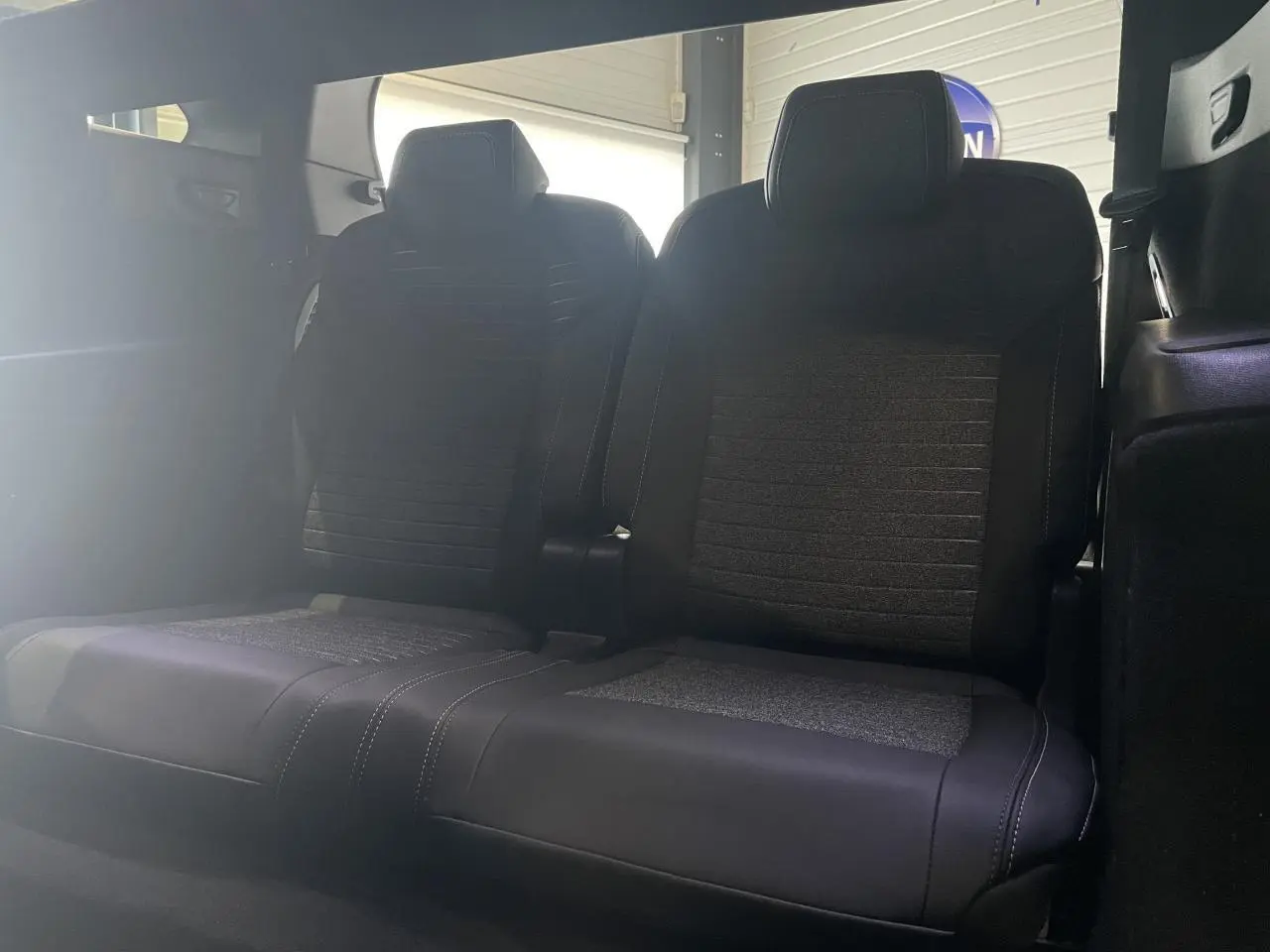Banquette arrière 2 places en tissu et cuir noir du Peugeot 5008 2025 vue de face dans l'habitacle.