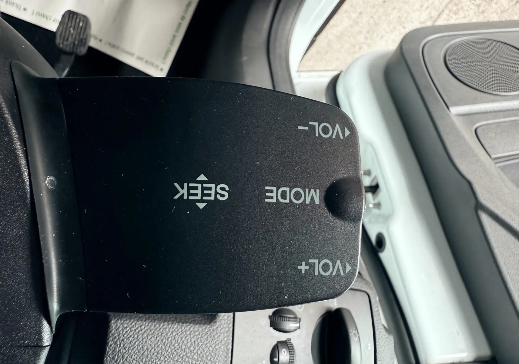 Gros plan sur la commande de volume et mode audio du Ford Kuga 2.0 TDCI blanc, côté conducteur intérieur.