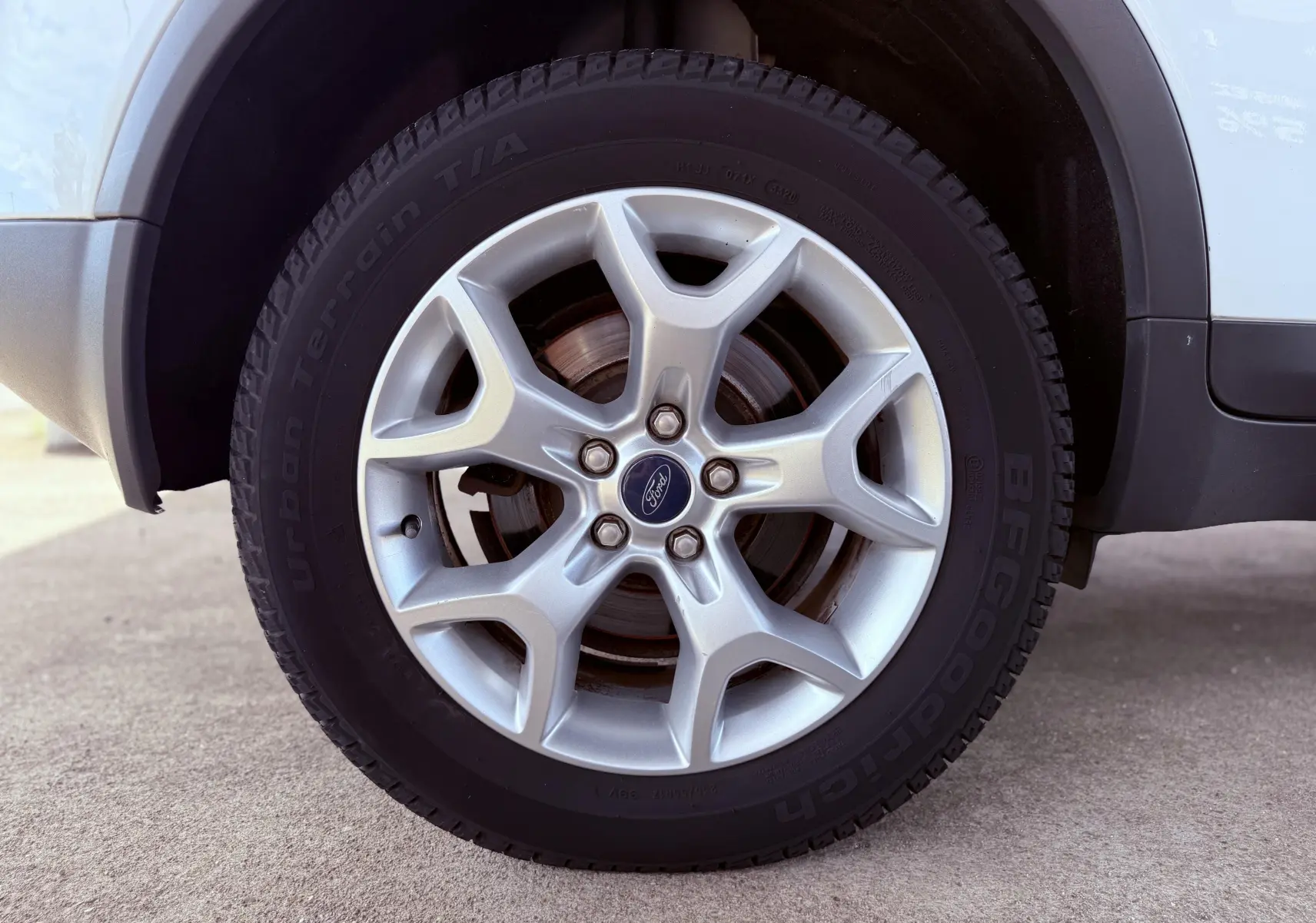 Gros plan sur la roue avant droite d’un Ford Kuga blanc avec jante alliage argent et pneu BFGoodrich.