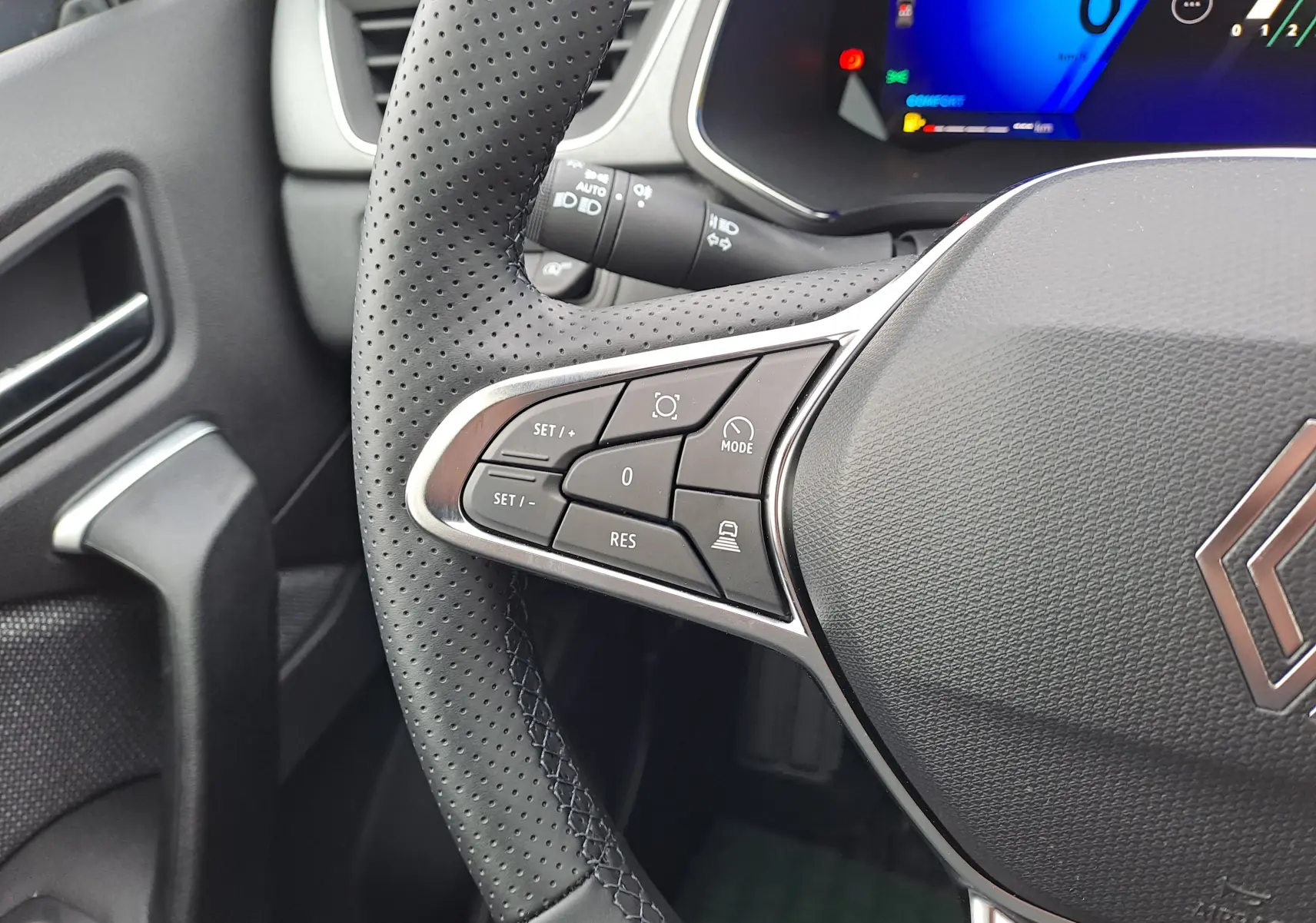 Gros plan sur le volant perforé côté gauche du Renault Symbioz 2025 avec commandes intégrées et tableau de bord numérique.