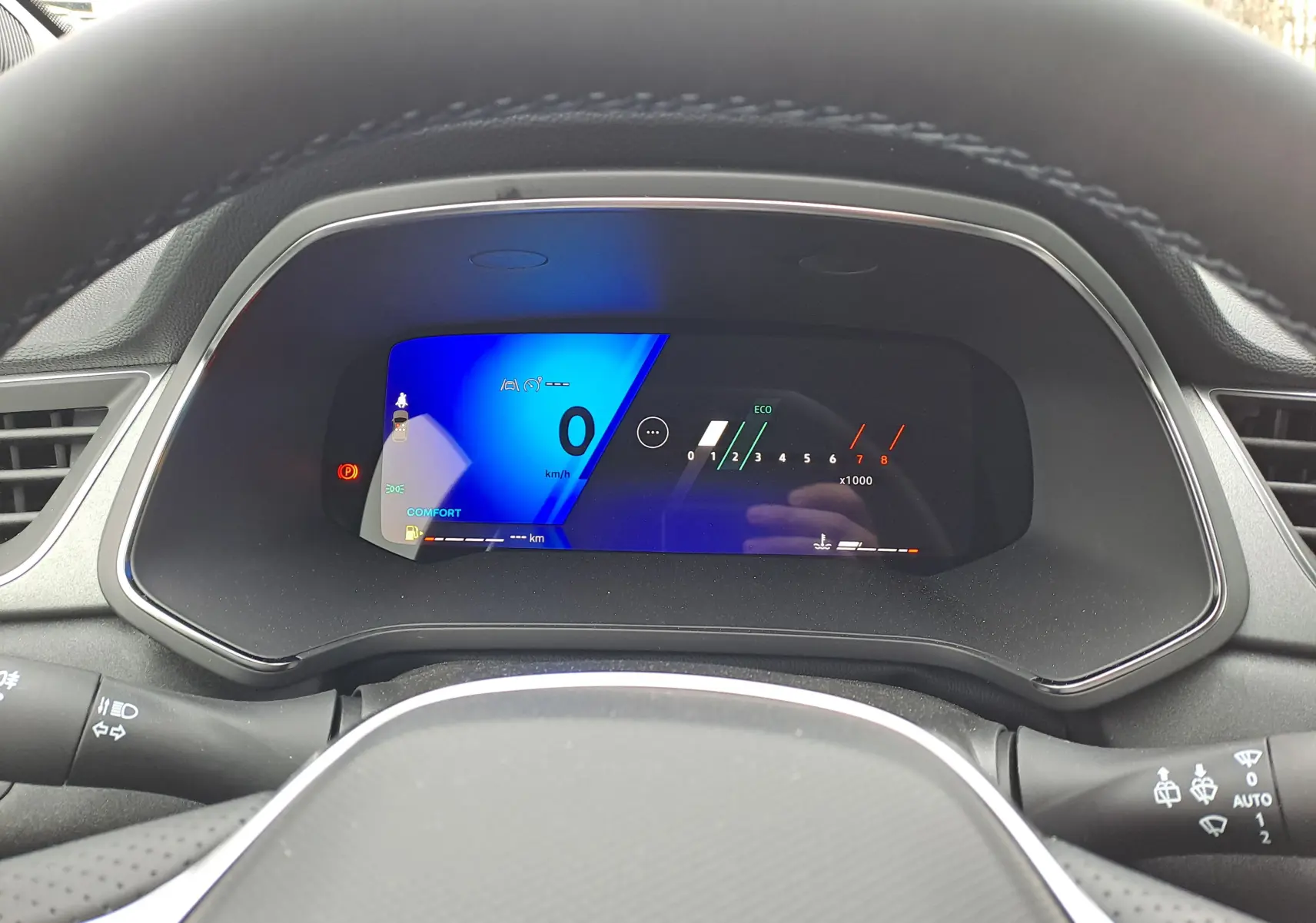 Tableau de bord numérique de la Renault Symbioz bleu mercure, affichage vitesse et compte-tours vu depuis le poste de conduite.