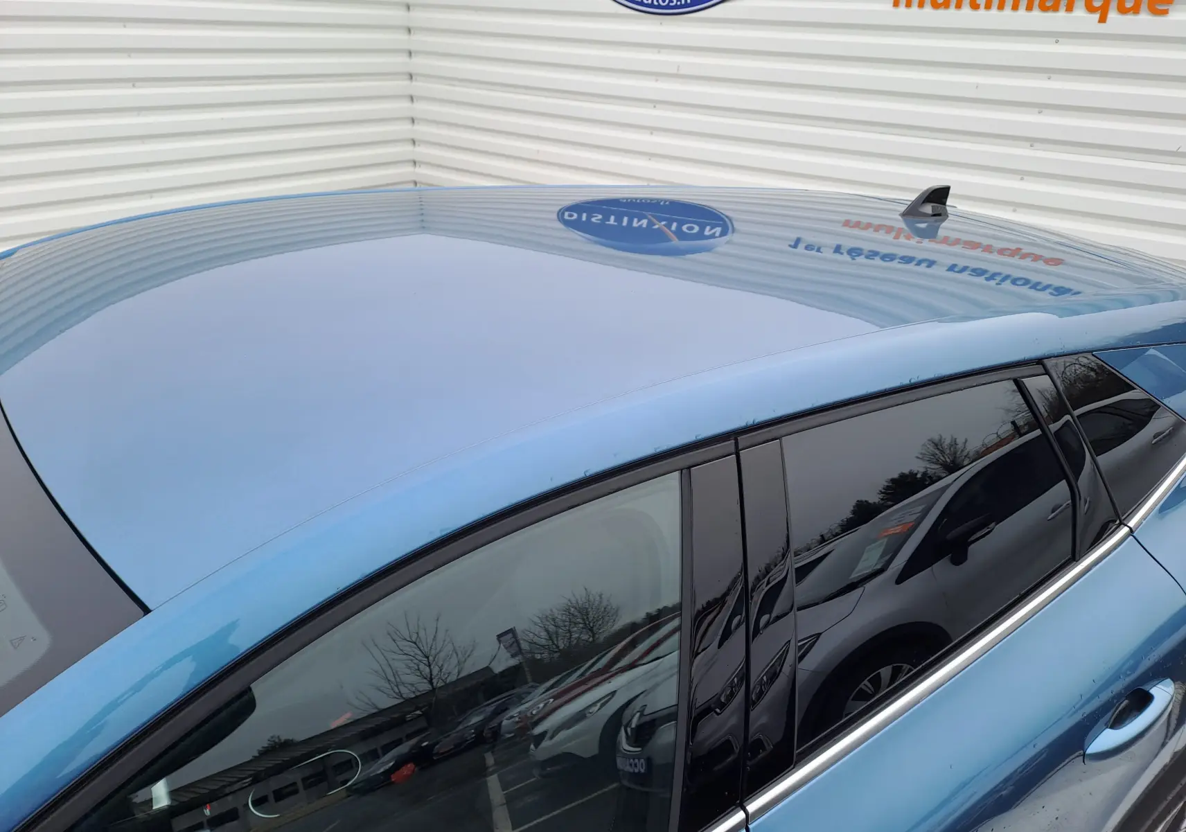 Vue rapprochée du toit et côté gauche bleu mercure du Renault Symbioz 2025 avec vitres teintées et antenne requin.