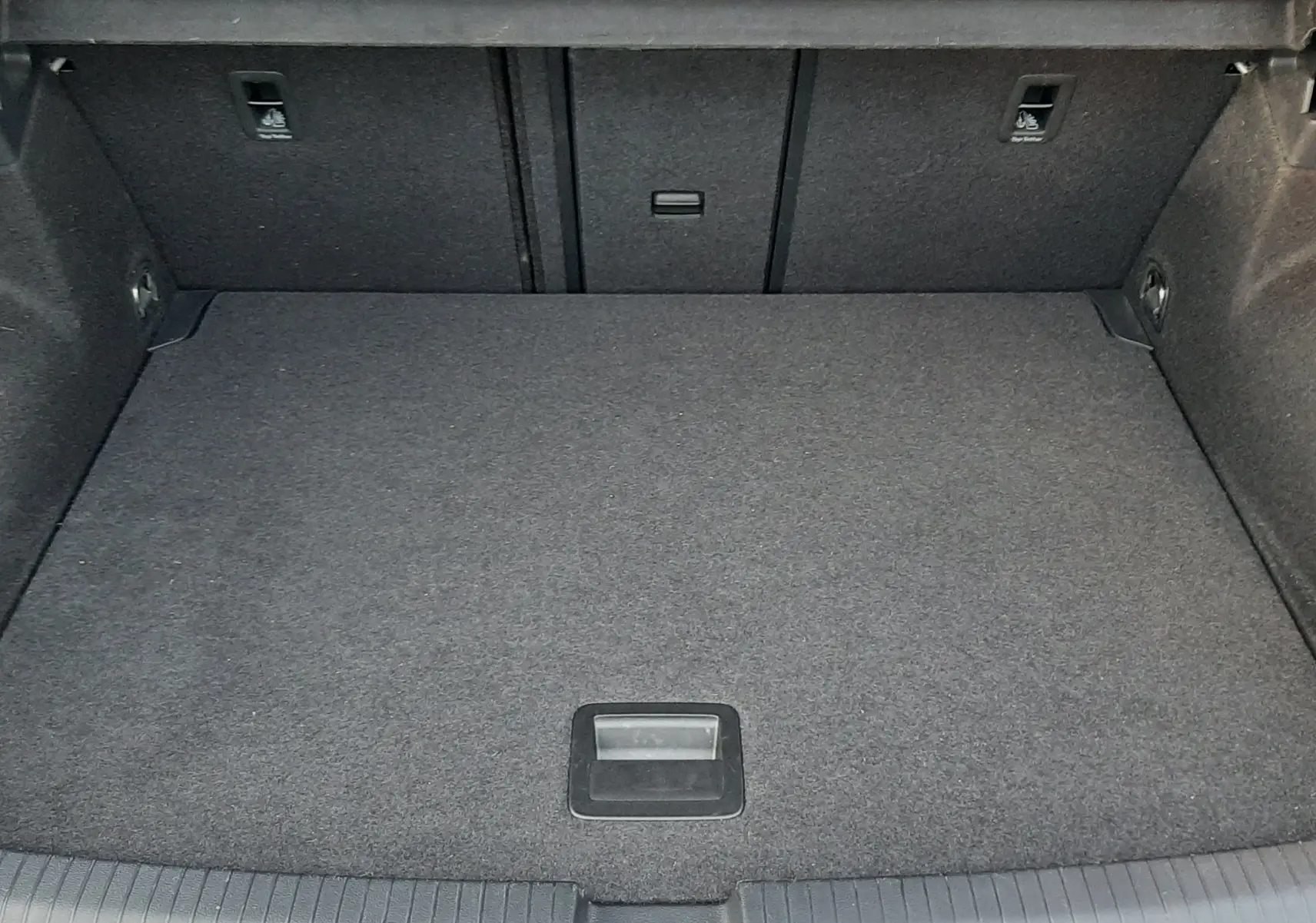 Coffre spacieux et propre du Volkswagen T-Roc gris pyrite, vue intérieure depuis l'ouverture arrière.