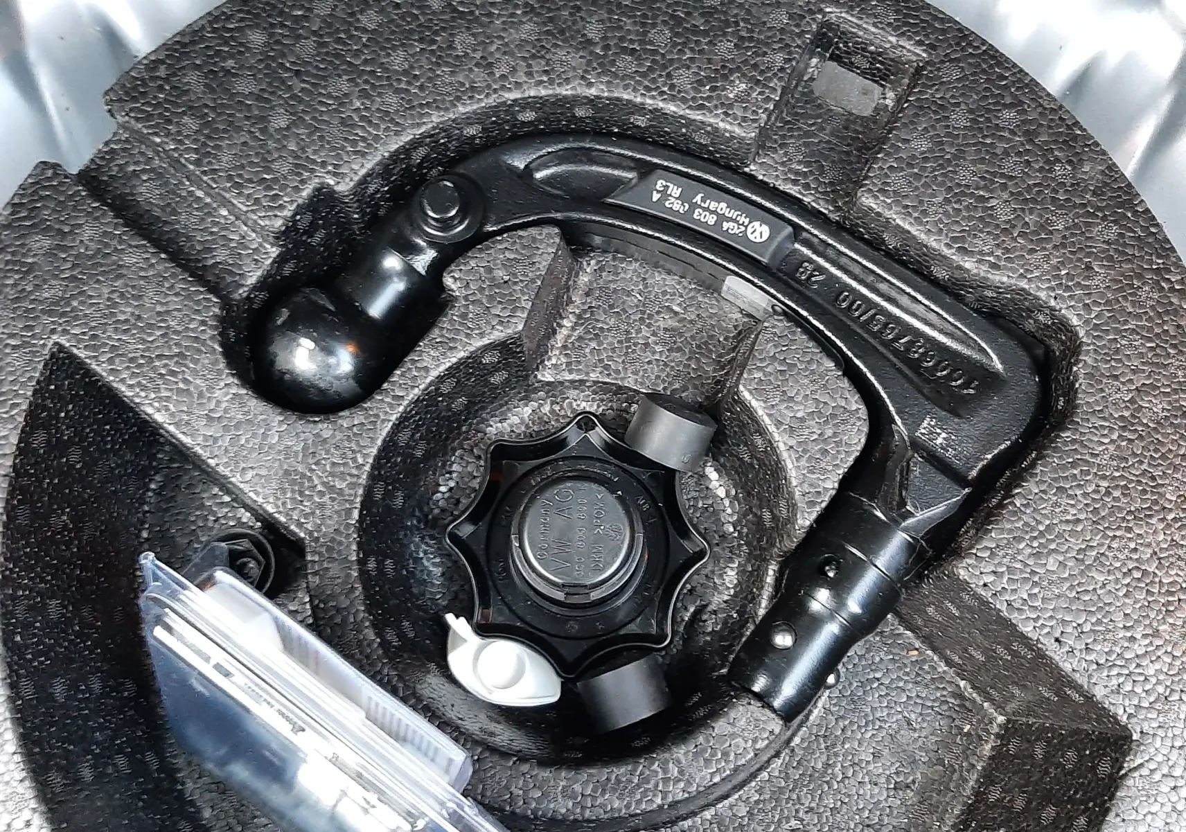 Gros plan sur l'attelage amovible rangé dans le coffre du Volkswagen T-Roc gris pyrite 2023.