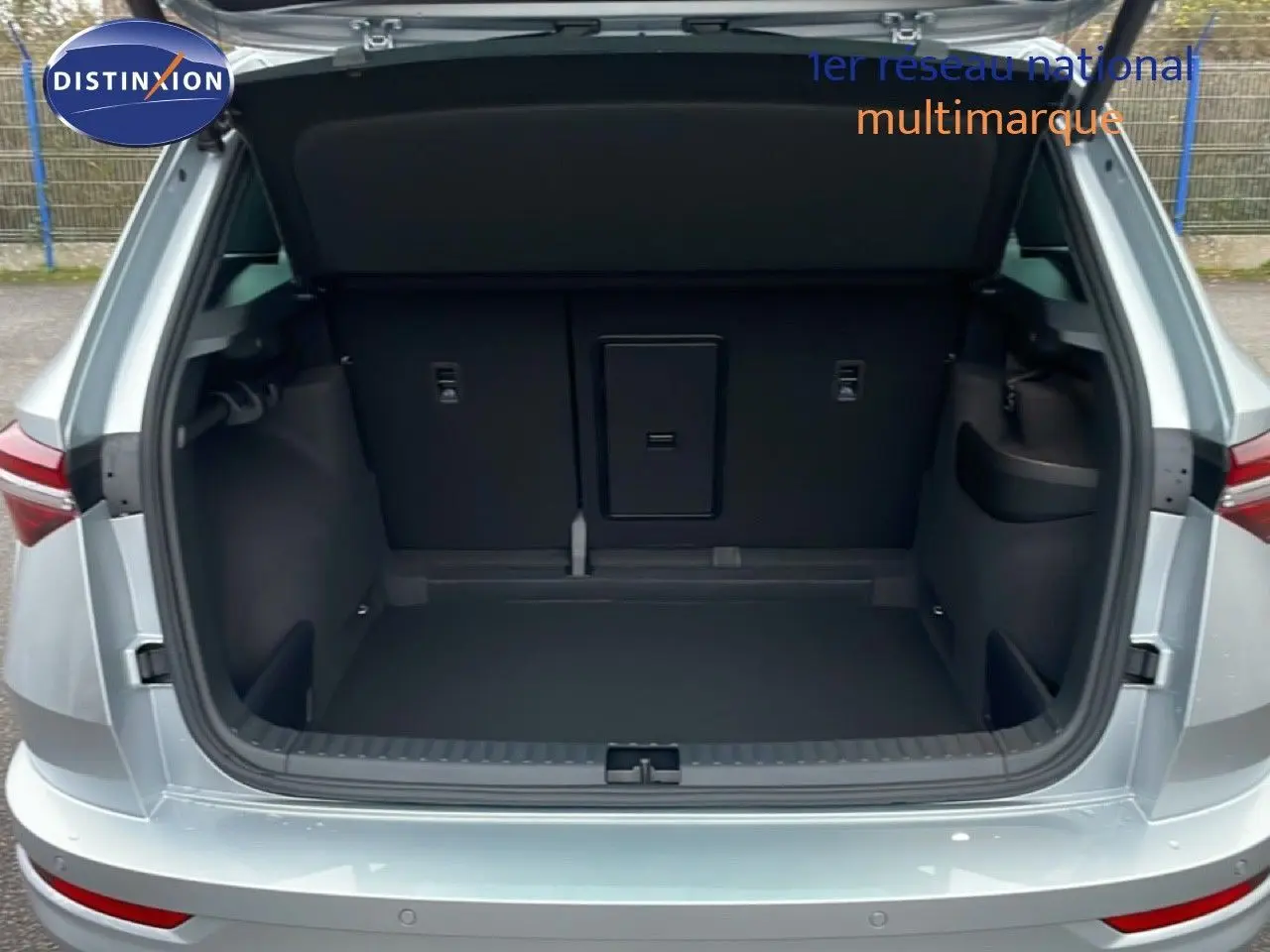 Coffre ouvert vu de l'arrière d'un Skoda Karoq gris argent métal 2025, montrant un espace de chargement spacieux.