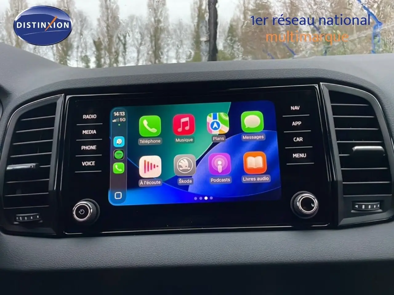 Écran tactile central du Skoda Karoq 2025 affichant les applications connectées, entouré de commandes noires.