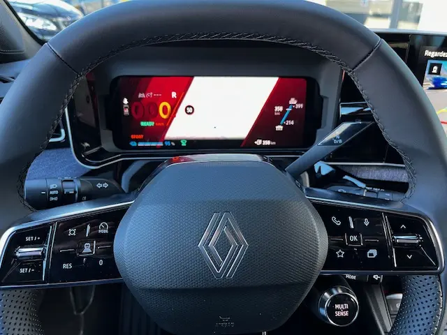 Vue rapprochée du volant et du combiné numérique de la Renault R5 Techno électrique jaune 2024, affichage multifonctions.